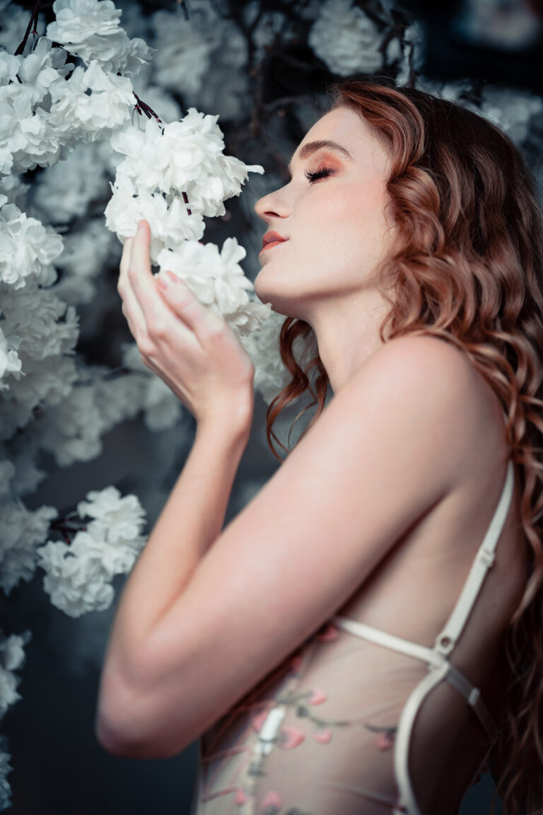 A beautiful woman sniffing flowers in lingerie